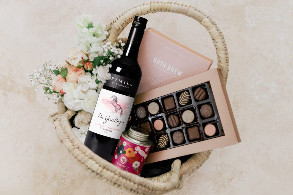 A bottle of wine and a package of chocolates

Description automatically generated with low confidence